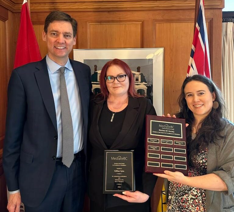 The 2022 Jani Award winner, Colleen Spier, K.C. holding an award plaque and standing between B.C. Premier David Eby and Mediate BC Co-Chair Robin Phillips.